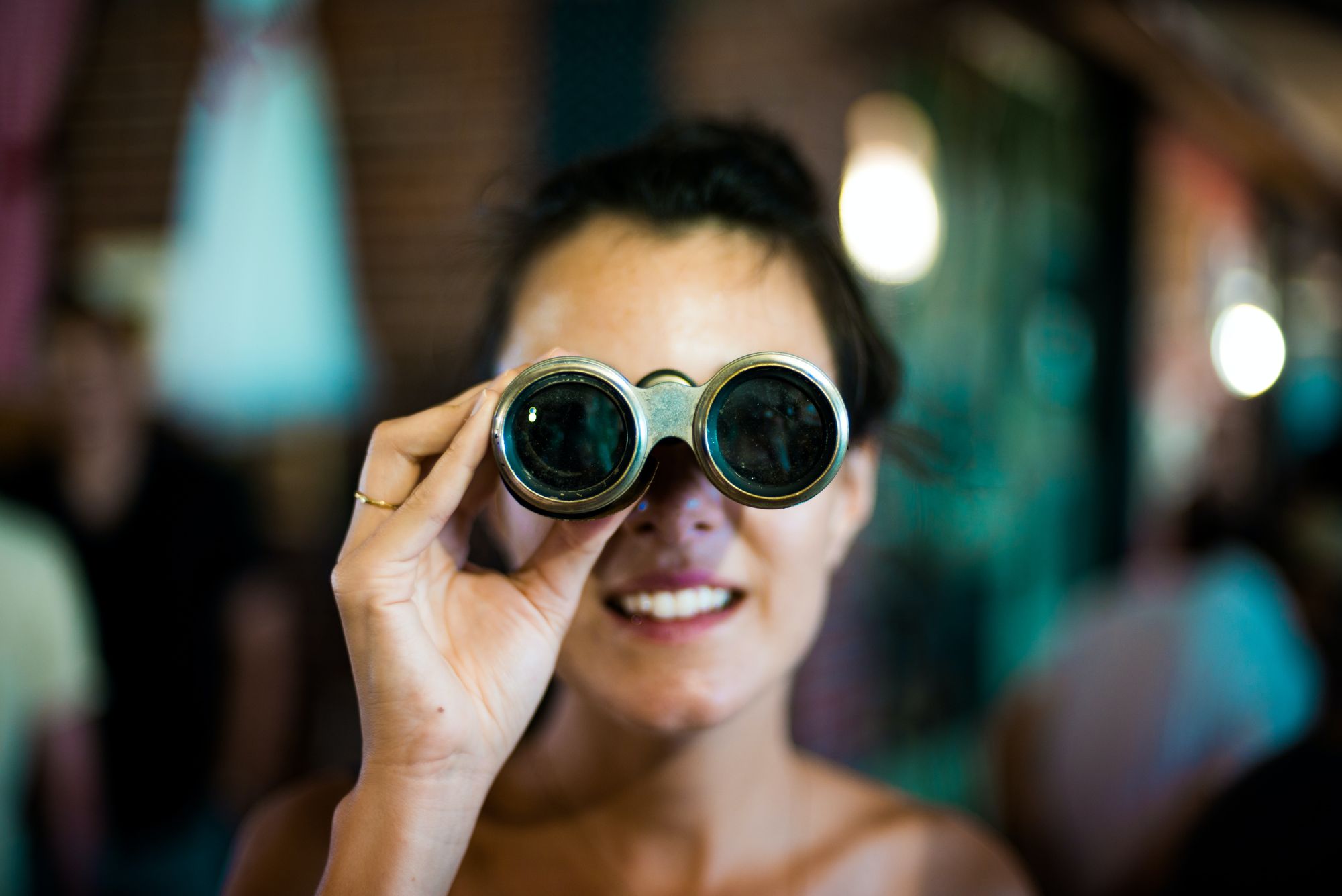 Someone looking through a pair of binoculars directly at the camera.