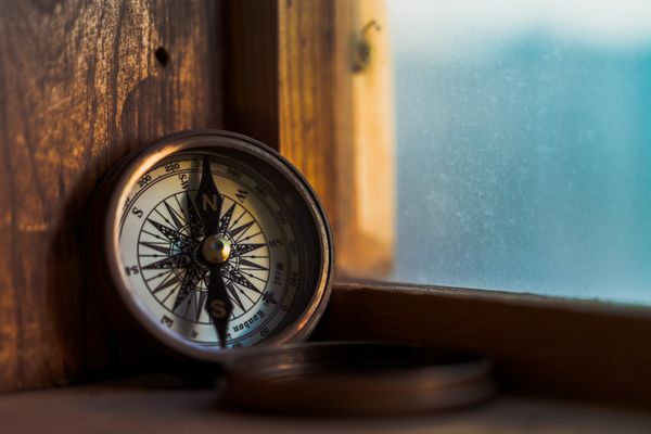 a compass sitting in a window corner.