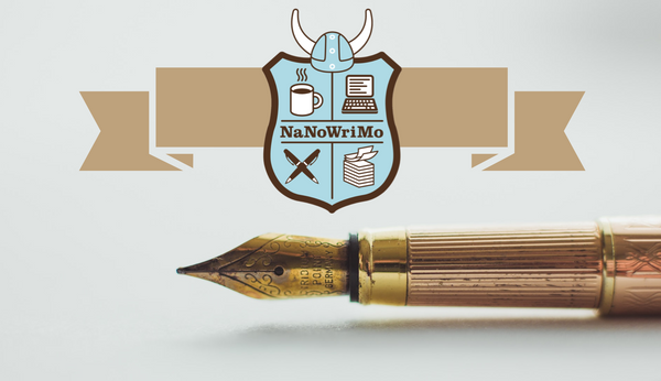 A close-up of a golden fountain pen with the logo of NaNoWriMo above it.